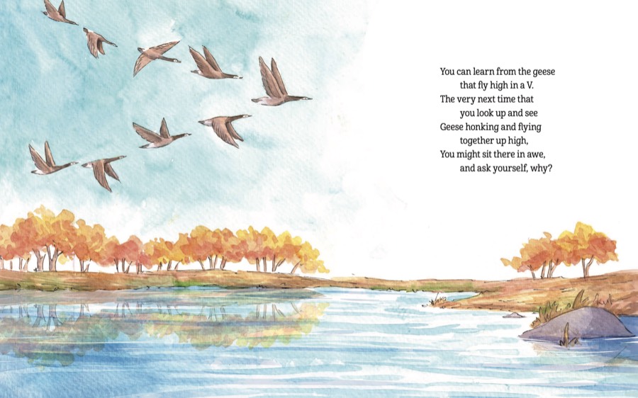 Geese flying in a V above an autumn river lined with golden trees